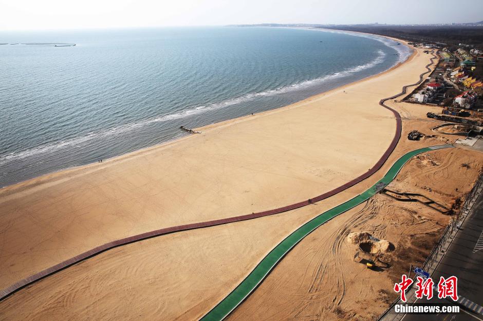 3月13日，秦皇島萬(wàn)米臨海沙灘木棧道。據了解，該木棧道全長(cháng)約4200米，與北戴河區原有的7500米木棧道對接后全線(xiàn)總長(cháng)度1.17萬(wàn)米，整個(gè)木棧道東起秦皇島體育基地游船碼頭，西至北戴河濕地公園，呈波浪形蜿蜒10.4公里海岸線(xiàn)。 中新社發(fā) 曹建雄 攝 CNSPHOTO