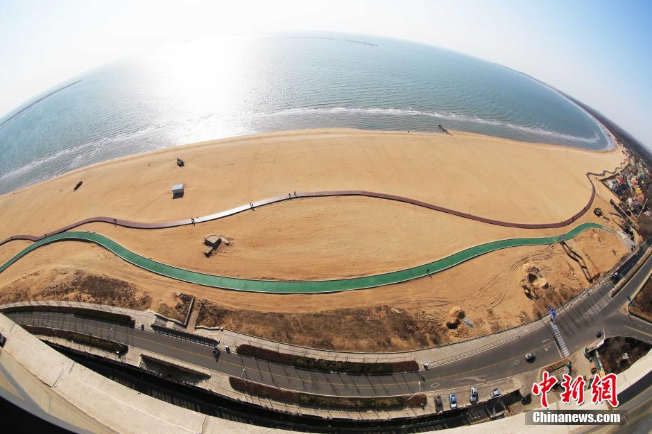 3月13日，秦皇島萬(wàn)米臨海沙灘木棧道。據了解，該木棧道全長(cháng)約4200米，與北戴河區原有的7500米木棧道對接后全線(xiàn)總長(cháng)度1.17萬(wàn)米，整個(gè)木棧道東起秦皇島體育基地游船碼頭，西至北戴河濕地公園，呈波浪形蜿蜒10.4公里海岸線(xiàn)。 中新社發(fā) 曹建雄 攝 CNSPHOTO